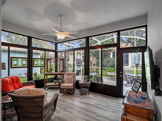 sunroom / solarium featuring a ceiling fan