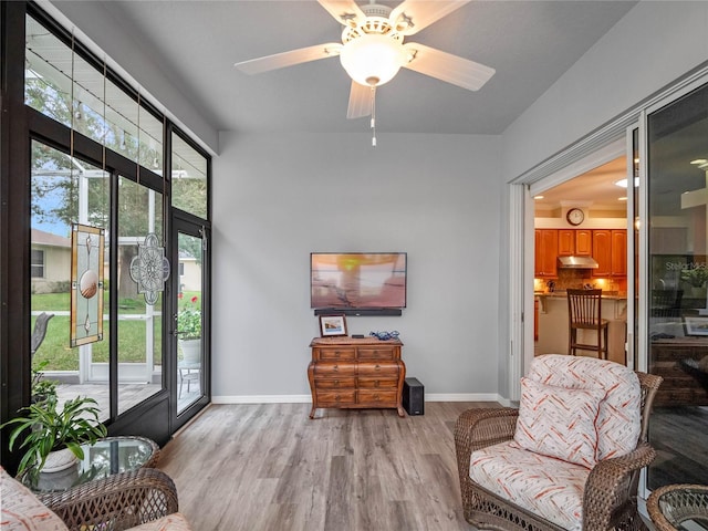 sitting room featuring light wood-type flooring, baseboards, and ceiling fan