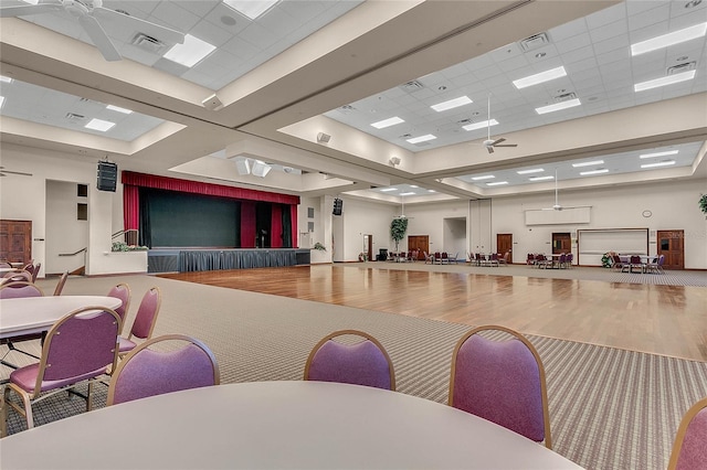 misc room with a paneled ceiling, wood finished floors, visible vents, and ceiling fan