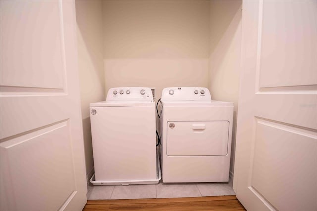 laundry area with hardwood / wood-style flooring and washing machine and clothes dryer