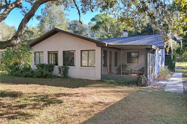 exterior space featuring a lawn and a sunroom