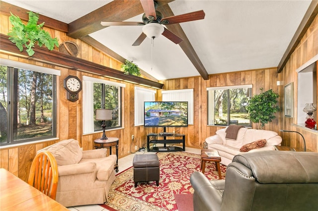 living room featuring lofted ceiling with beams, plenty of natural light, and wood walls