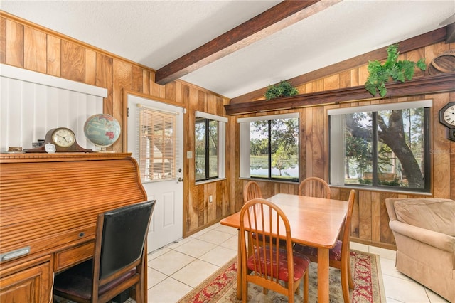 tiled dining area with wood walls, lofted ceiling with beams, and a textured ceiling