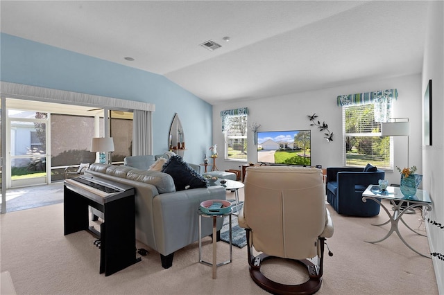 carpeted living room with a wealth of natural light and lofted ceiling