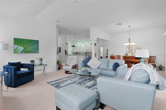 carpeted living room featuring a notable chandelier