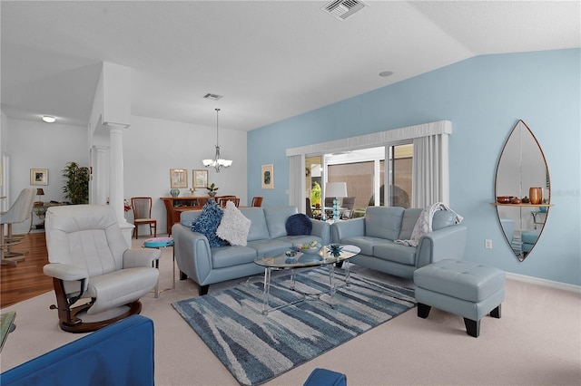 carpeted living room featuring decorative columns, lofted ceiling, and a notable chandelier