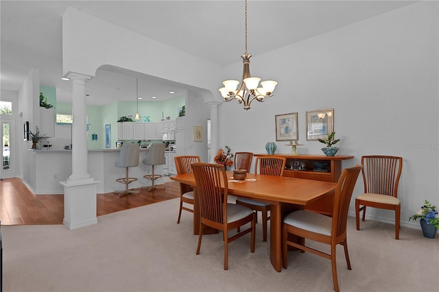 dining area with light wood-type flooring and an inviting chandelier