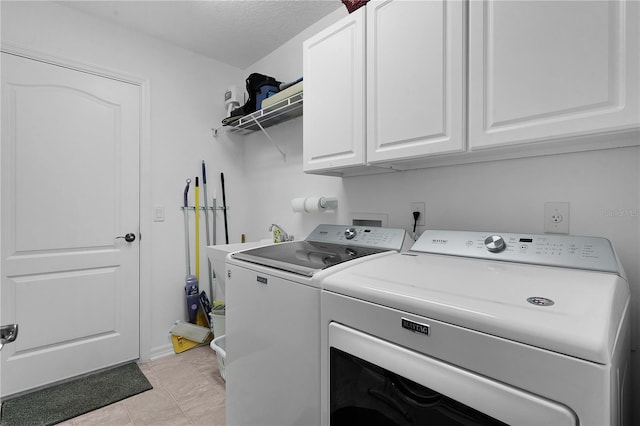 laundry area with cabinets, independent washer and dryer, a textured ceiling, and light tile patterned floors