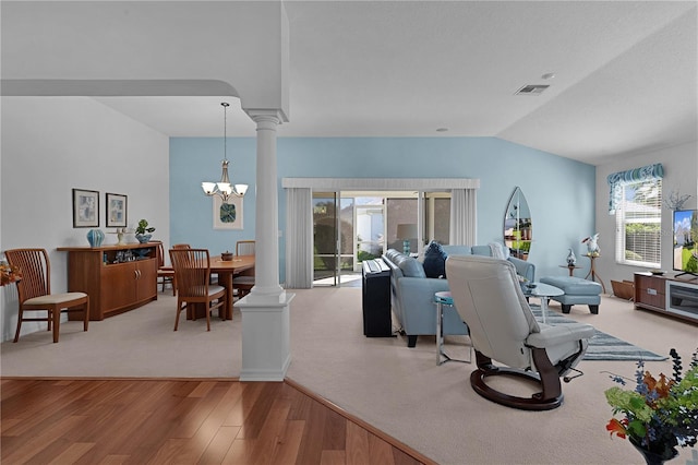 living room with plenty of natural light, wood-type flooring, lofted ceiling, and a notable chandelier