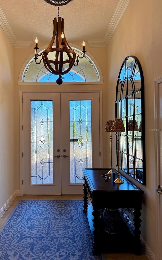 entrance foyer featuring crown molding, french doors, a chandelier, and a textured ceiling