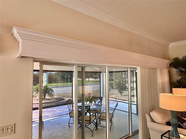 doorway featuring plenty of natural light, crown molding, carpet floors, and a textured ceiling