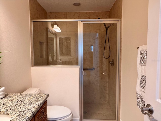 bathroom featuring toilet, an enclosed shower, a textured ceiling, and vanity