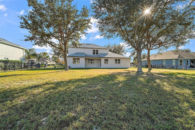 traditional-style home with a front lawn and a fenced backyard