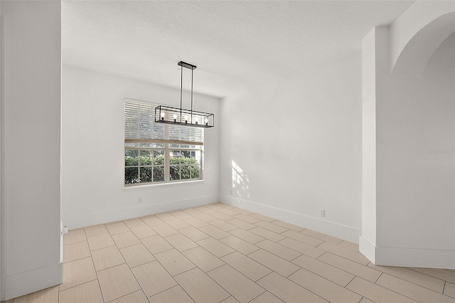 unfurnished dining area featuring a textured ceiling