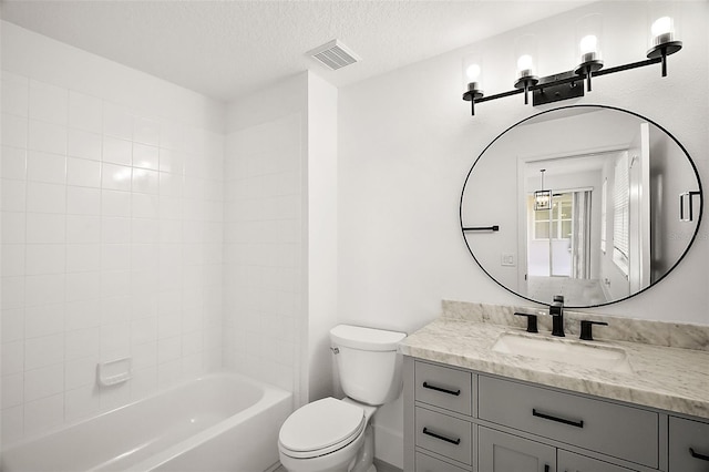 full bathroom featuring vanity, toilet, a textured ceiling, and tiled shower / bath