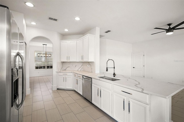 kitchen featuring ceiling fan with notable chandelier, sink, kitchen peninsula, white cabinetry, and stainless steel appliances