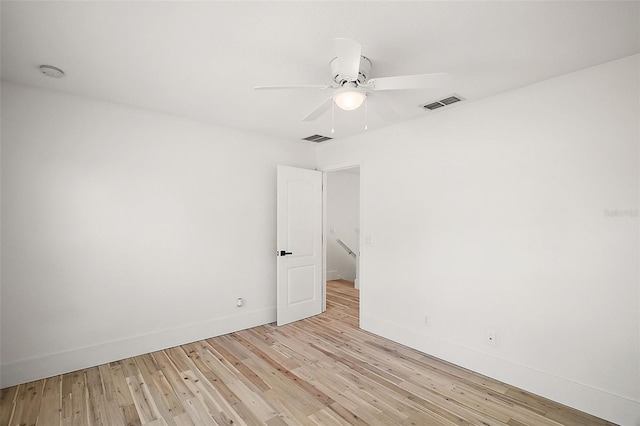 spare room with ceiling fan and light wood-type flooring