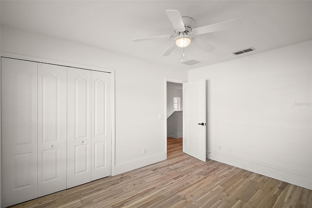 unfurnished bedroom featuring ceiling fan, light hardwood / wood-style floors, and a closet