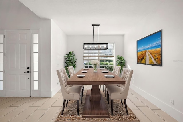 dining room featuring an inviting chandelier and baseboards