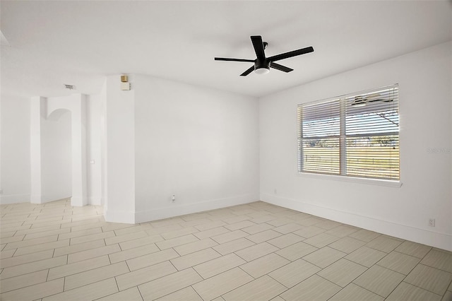 spare room featuring ceiling fan and baseboards