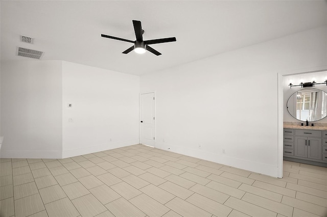 unfurnished room featuring baseboards, a sink, visible vents, and a ceiling fan