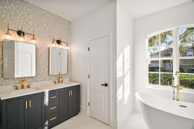 bathroom with a healthy amount of sunlight, wallpapered walls, marble finish floor, and a sink