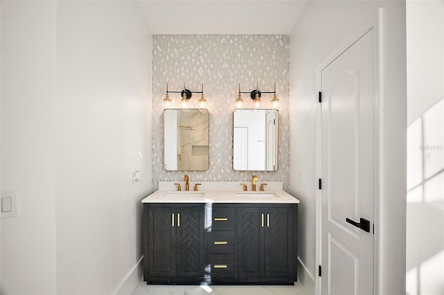 bathroom with a sink, baseboards, and double vanity