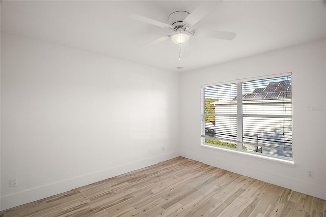 unfurnished room with ceiling fan, light wood-style flooring, and baseboards