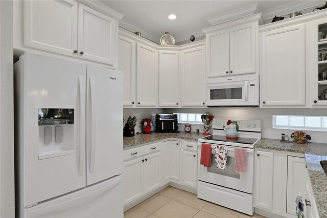 kitchen with a wealth of natural light, white cabinetry, and white appliances