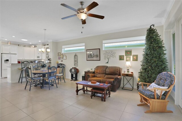 living room with light tile patterned flooring, ceiling fan with notable chandelier, and ornamental molding