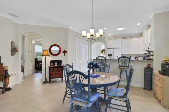 dining area featuring ornamental molding, light tile patterned floors, and an inviting chandelier