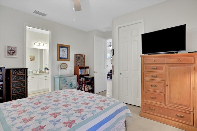 bedroom featuring light tile patterned floors, ensuite bathroom, and ceiling fan