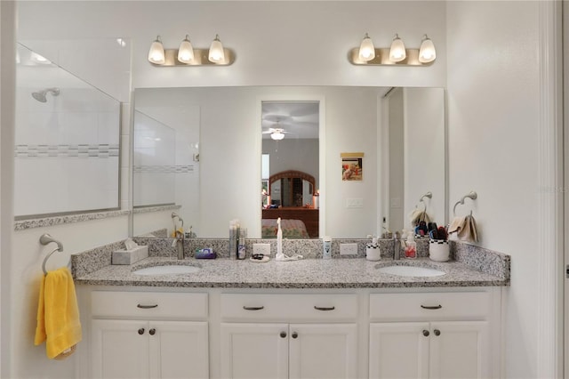 bathroom with a tile shower, ceiling fan, and vanity