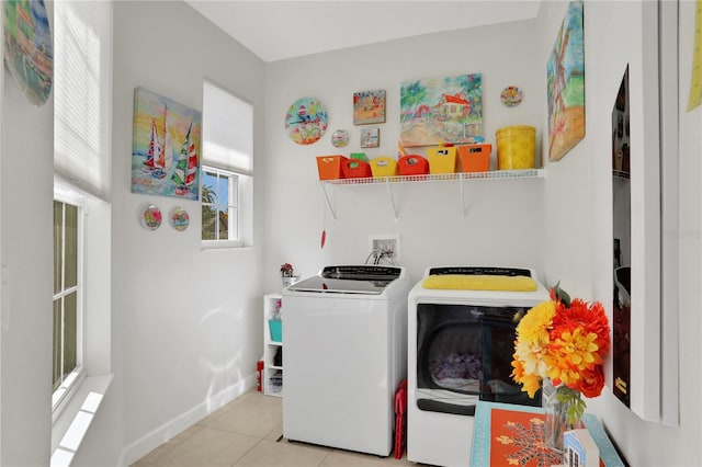 laundry area featuring washer and clothes dryer and light tile patterned flooring