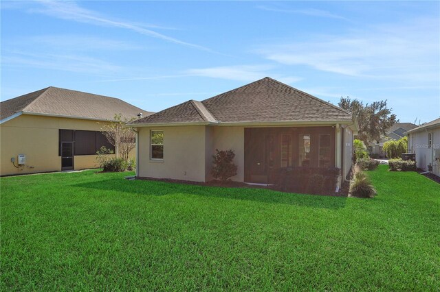 rear view of house featuring a sunroom and a yard