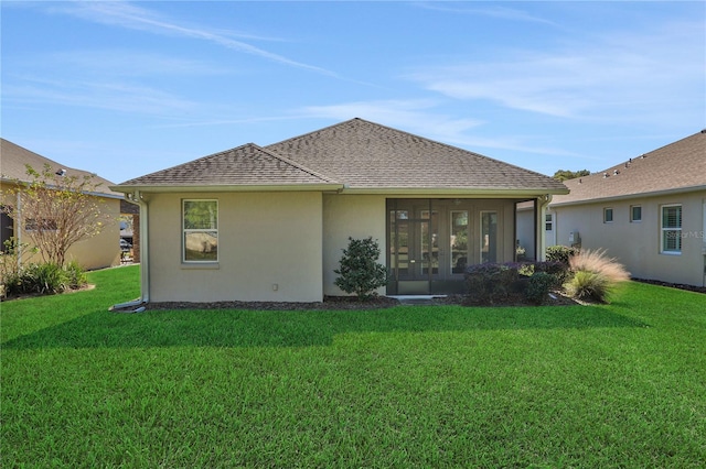 rear view of property featuring a lawn and a sunroom