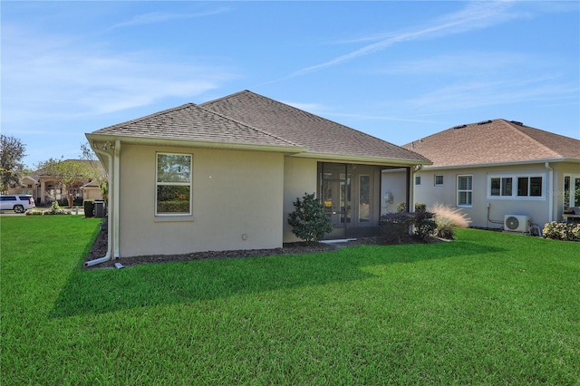 rear view of house featuring ac unit, a sunroom, central AC unit, and a lawn