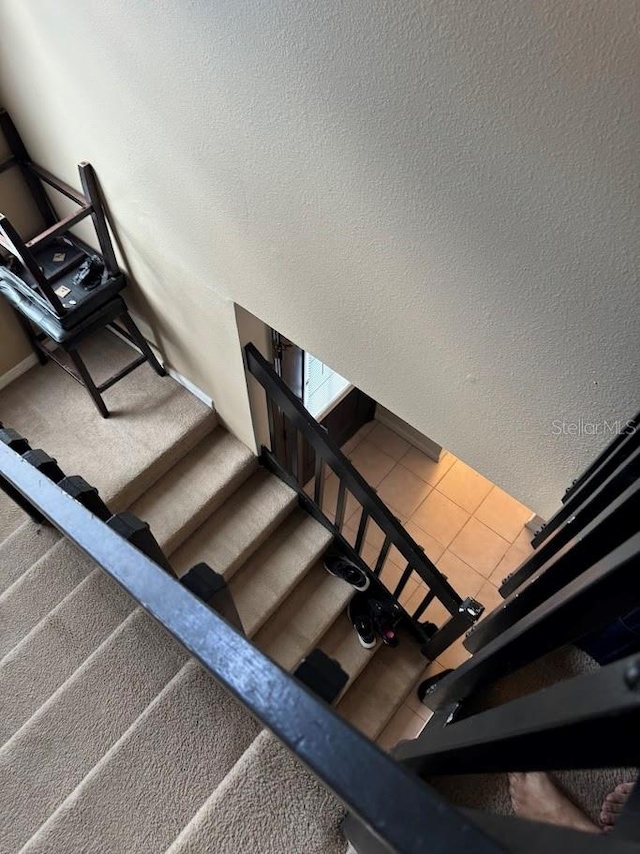 stairs featuring tile patterned floors and a textured ceiling