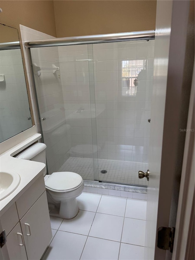 full bathroom with a stall shower, vanity, toilet, and tile patterned floors