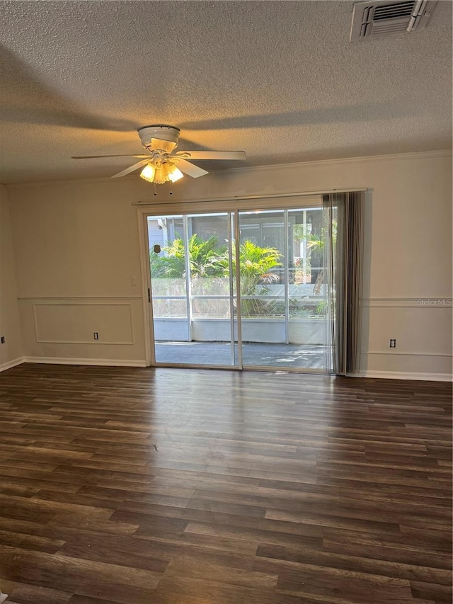 empty room with a ceiling fan, visible vents, dark wood finished floors, and a textured ceiling