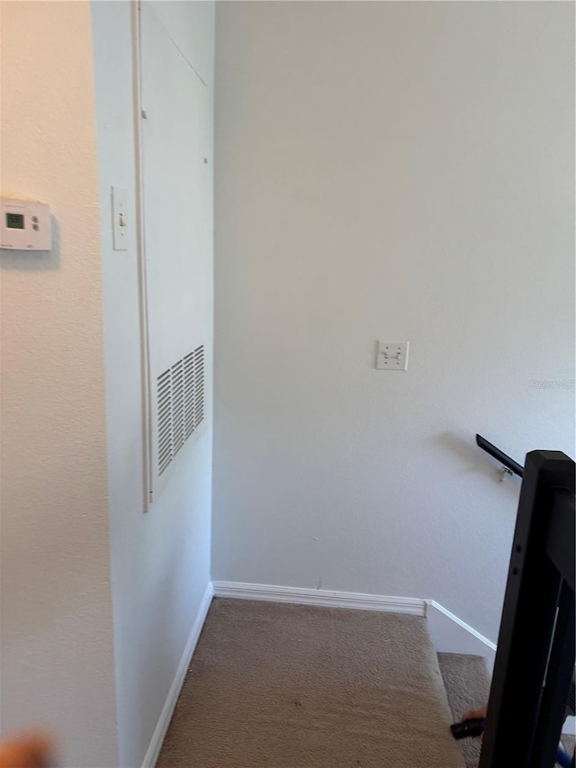 hallway featuring carpet and baseboards