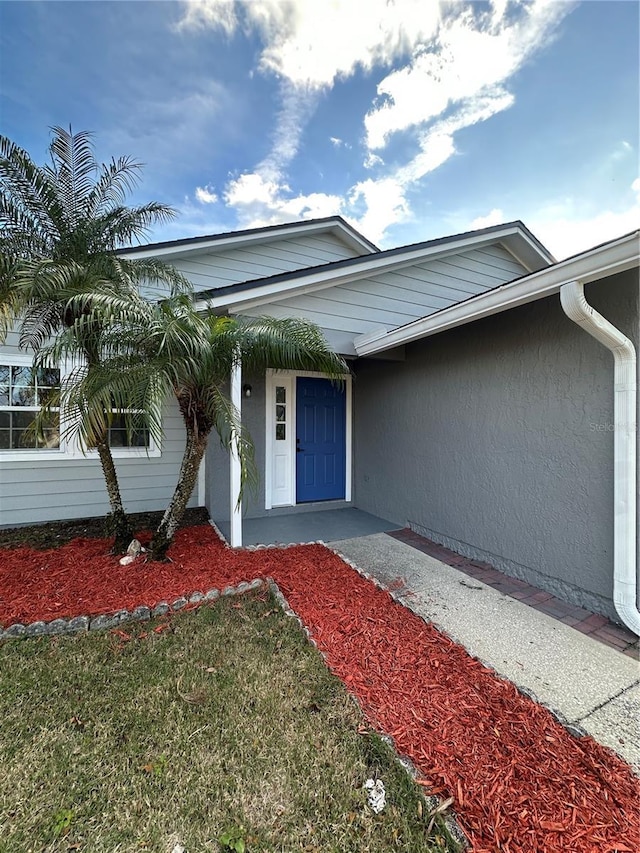 property entrance with a lawn