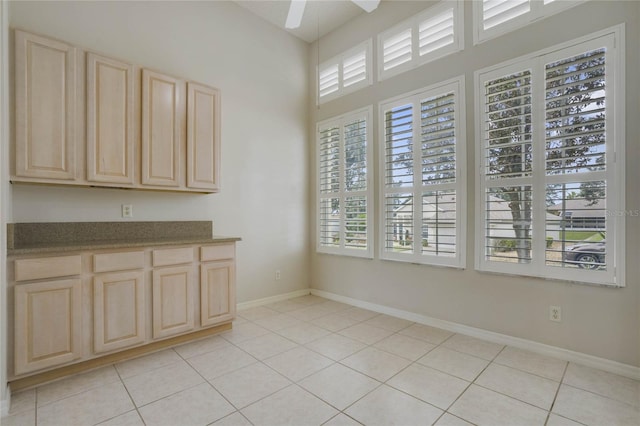 kitchen featuring ceiling fan, light brown cabinets, and light tile patterned flooring