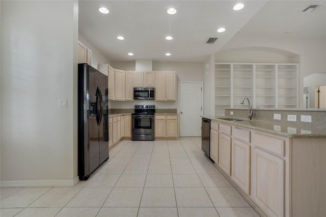 kitchen with black appliances, sink, light tile patterned floors, light brown cabinetry, and light stone counters