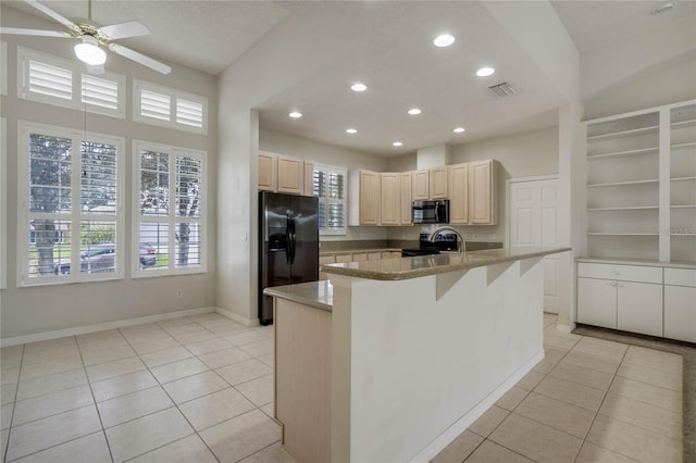 kitchen with light tile patterned floors, stainless steel appliances, plenty of natural light, and a kitchen island with sink