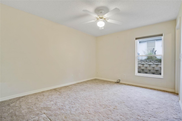 carpeted empty room featuring ceiling fan and a textured ceiling