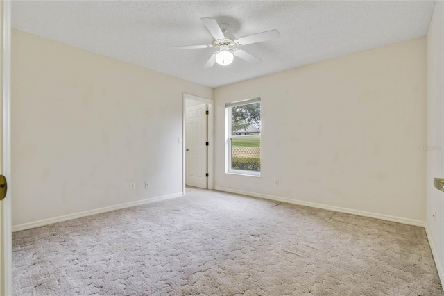 carpeted empty room with ceiling fan and a textured ceiling