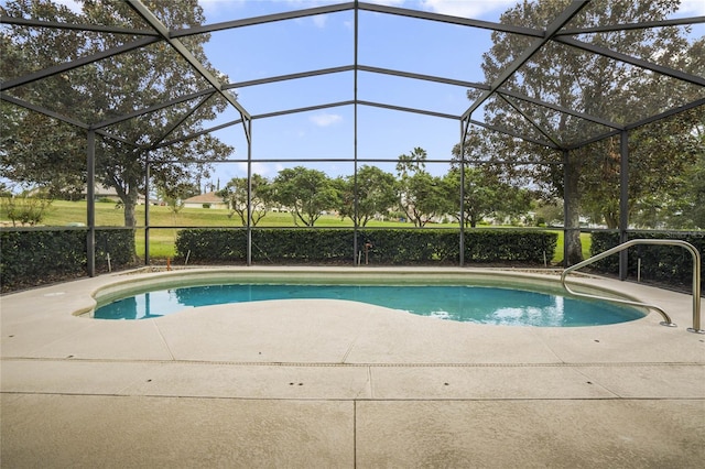 view of swimming pool featuring a patio and glass enclosure