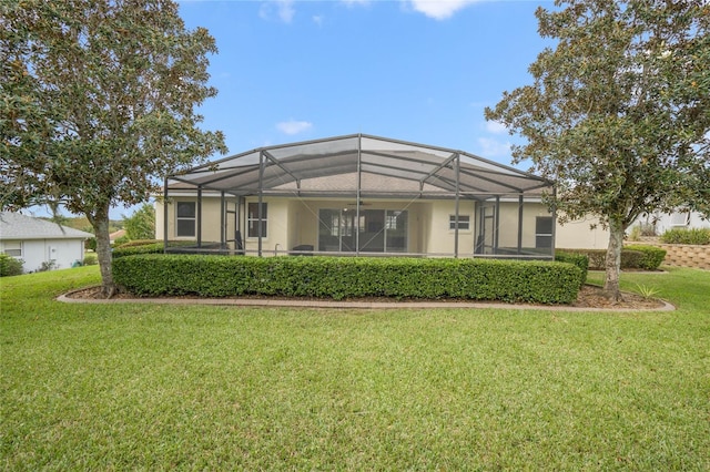 rear view of property with a lanai and a yard