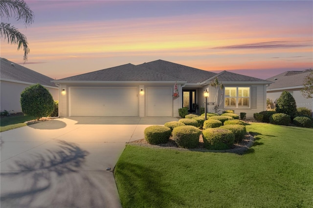 view of front of property with a yard and a garage